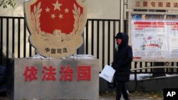 一名北京居民走过三里河街道普法宣传栏。(2021年11月8日)