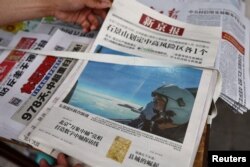 北京街头报摊上的报纸头版展示中国空军参加在台湾周边海空领域进行军演的照片。(2022年8月8日)