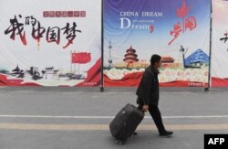 资料照:一名男子走过北京街头张贴的中国梦宣传画。(2017年4月4日)