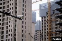 上海一处正在修建的公寓楼盘旁竖立着一个监控摄像头。(2022年7月20日)