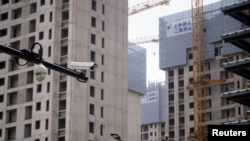 上海一处正在修建的公寓楼盘旁竖立着一个监控摄像头。(2022年7月20日)