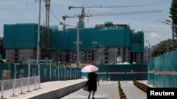 一名女子走过北京的一处住宅楼建筑工地。(2022年7月15日)