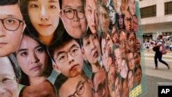 资料照片:香港街头竖起画有香港民主派活动人士头像的横幅。(2021年7月1日)