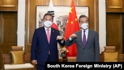 中国外长王毅在山东青岛会见到访的韩国外交部长官朴振。(2022年8月9日)