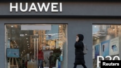 资料照:一名女子走过乌克兰首都基辅市中心的一家华为商店。(2019年11月11日)