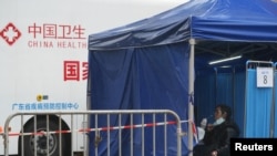 香港东涌居民在接受新冠病毒核酸检测,后面的车辆是中国广东省疾病预防控制中心的移动测试车。(2022年2月21日)