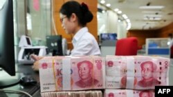 2018年7月23日在中国江苏省南通市的一家银行,一名员工处理100元纸币。