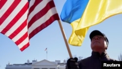 Ілюстративне зображення: активіст тримає американський та український прапори біля Білого дому у Вашингтоні. 29 січня 2022 року. Фото Reuters