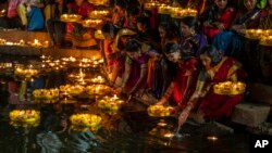 Hindu women light oil lamps at the Banganga pond as they celebrate Dev Diwali festival in Mumbai, India,