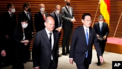 2022年4月28日,在东京首相办公室举行双边会议前,德国总理朔尔茨(左)和日本首相岸田文雄在观看仪仗队后走在一起。