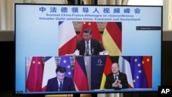 屏幕显示中国领导人习近平、法国总统马克龙和德国总理朔尔茨在视频会议上商讨乌克兰危机问题。(2022年3月8日)