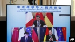 屏幕显示中国领导人习近平、法国总统马克龙和德国总理朔尔茨在视频会议上商讨乌克兰危机问题。(2022年3月8日)
