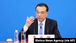 资料照:中国总理李克强在北京人大会堂全国人大会议闭幕后举行的记者会上讲话的照片。(2022年3月11日)