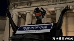 2022年11月28日,哥大智慧女神像眼睛被蒙上了红布,象征着与会者抗议中国政府清零政策的愚昧。(美国之音方冰拍摄)
