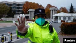 北京清华大学大门一名保安在阻止人们拍照。(2022年11月27日)