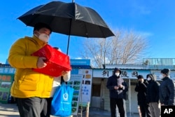 一名男子手捧亲人骨灰盒走出一家北京火葬场。(2022年12月17日)