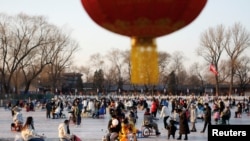 北京居民在冰封的湖面上滑冰玩耍。(2022年12月31日)