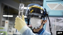 资料照片:一名工作人员正在检测福岛核废水中氚放射性元素的含量(2022年3月5日)