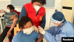 中国医护人员在上海郊区的村庄里为老年人接种新冠疫苗。(2022年12月21日)