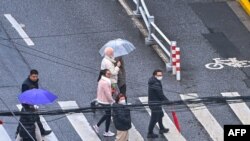 People walk on a street in the Jing'an district in Shanghai on Dec. 3, 2022.