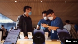 2022年9月16日,苹果新款iPhone 14在北京上市,一位顾客在苹果专卖店与销售交谈。(路透社)