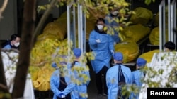 上海一家火葬场的工作人员走过数个逝者的尸袋。(2023年1月4日)