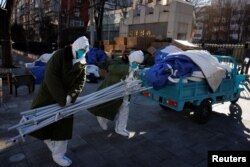 身穿防护服的大白拆除北京一个居民区的封控和检测装置。(2022年12月10日)