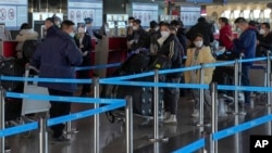 北京国际机场一个国际航班柜台的旅客等候托运行李。(2022年12月29日)