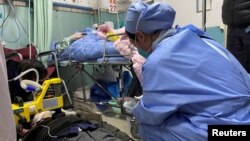 上海一家医院急诊室的一名医生正在给一名躺在地上的新冠病人进行心肺复苏。(2023年1月5日)