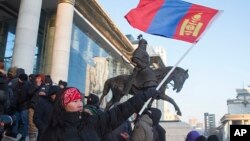 蒙古国示威者在首都乌兰巴托国家宫前挥舞国旗抗议与中国相关的一起煤炭交易腐败丑闻。(2022年12月5日)
