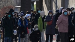 北京居民在一所医院的发热门诊前大排长龙。(美联社2022年12月11日照片)