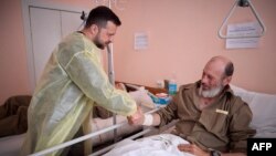 Президент України тисне руку пораненому солдату у шпиталі Харкова 16 травня 2024 року. Фото: Офіс президента України/AFP