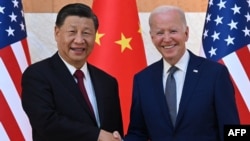 资料照片:美国总统乔·拜登(右)和中国国家主席习近平(左)2022年11月14日在印度尼西亚度假胜地巴厘岛努沙杜瓦举行的G20峰会期间握手。(法新社图片)
