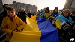 People carry a large Ukrainian flag during a protest against Russia's war on Ukraine, marking the first anniversary of Russia's full-scale, in Bucharest, Romania, on February 24, 2023. (Andreea Alexandru/AP)