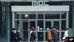 2022年11月10日,人们走过韩国首都首尔的公共给电视台MBC总部前