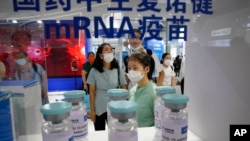 9月5日,在中国国际服务贸易洽谈会上,参观者在观看中国国药控股旗下CNBG采用mRNA技术生产的疫苗的巨型仿制瓶。