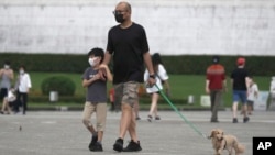 台北市民戴着口罩遛狗散步。(2022年4月27日)