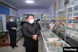 朝鲜官方2022年5月15日公布的领导人金正恩视察一家药店的情形。(朝中社)