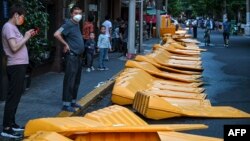 上海市民站在刚刚被推倒的用于封城的围栏旁。(2022年5月31日)