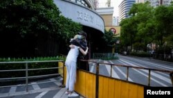 上海封城期间两名女子在一条被封的街道上拥抱。(2022年5月16日)