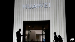 资料照片:购物者走过北京的一家华为商店。(2021年8月26日)