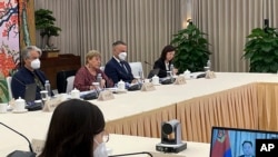 2022年5月24日,联合国人权事务高级专员巴切莱特(左二)在广州与中国公安部副部长杜航伟(右边电脑屏幕上)举行视频会议。(照片由联合国人权高专办通过美联社向外界发布。)