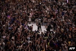 资料照:香港民众在一处商场内跟着演奏者合唱“GLORY TO HONG KONG”,即反修例歌曲《愿荣光归香港》的英文歌曲。(2019年9月11日)