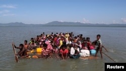 FILE PHOTO: Rohingya refugees cross the Naf River with an improvised raft to reach Bangladesh at Sabrang near Teknaf, Bangladesh, November 10, 2017. REUTERS/Mohammad Ponir Hossain/File Photo FROM THE FILES - 3RD ANNIVERSARY OF ROHINGYA MUSLIM EXODUS FROM