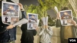 4名中国内地留学生12月10日国际人权日,在香港中文大学校园内举起白纸火炬及标语,呼吁各界关注中国内地“白纸示威”被捕人士,敦促当局尽快放人 (美国之音/汤惠芸)