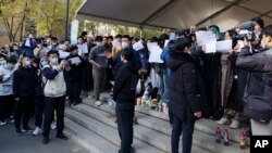 北京清华大学的学生手举白纸抗议严厉的防疫政策,悼念日前在新疆乌鲁木齐市死于火灾的至少10名遇难者。 (2022年11月27日)