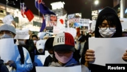 在日本的中国人在东京街头手举白纸,抗议中国的新冠封控措施。(2022年11月30日)