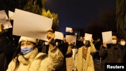 北京民众手举白纸上街游行,抗议中国严厉的防疫政策,悼念乌鲁木齐火灾死难者。(2022年11月27日)