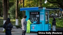 浙江金华市民排队等候在移动诊室就诊。(2022年12月22日)