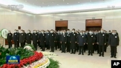 2022年12月5日,中国中央电视台播放的视频截图中,中国国家主席习近平和前任胡锦涛与其他领导人一起向前国家主席江泽民的遗体表示敬意。